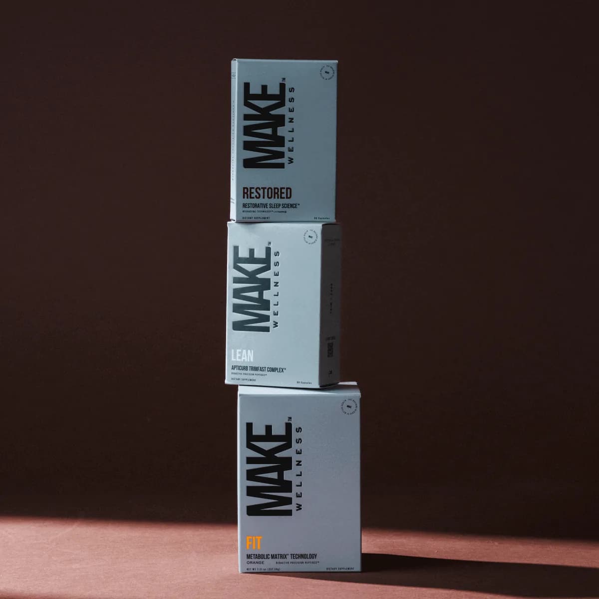 Caixas de RESTORED, LEAN e FIT da MAKE Wellness empilhadas, o MAKE 3 Breakthrough