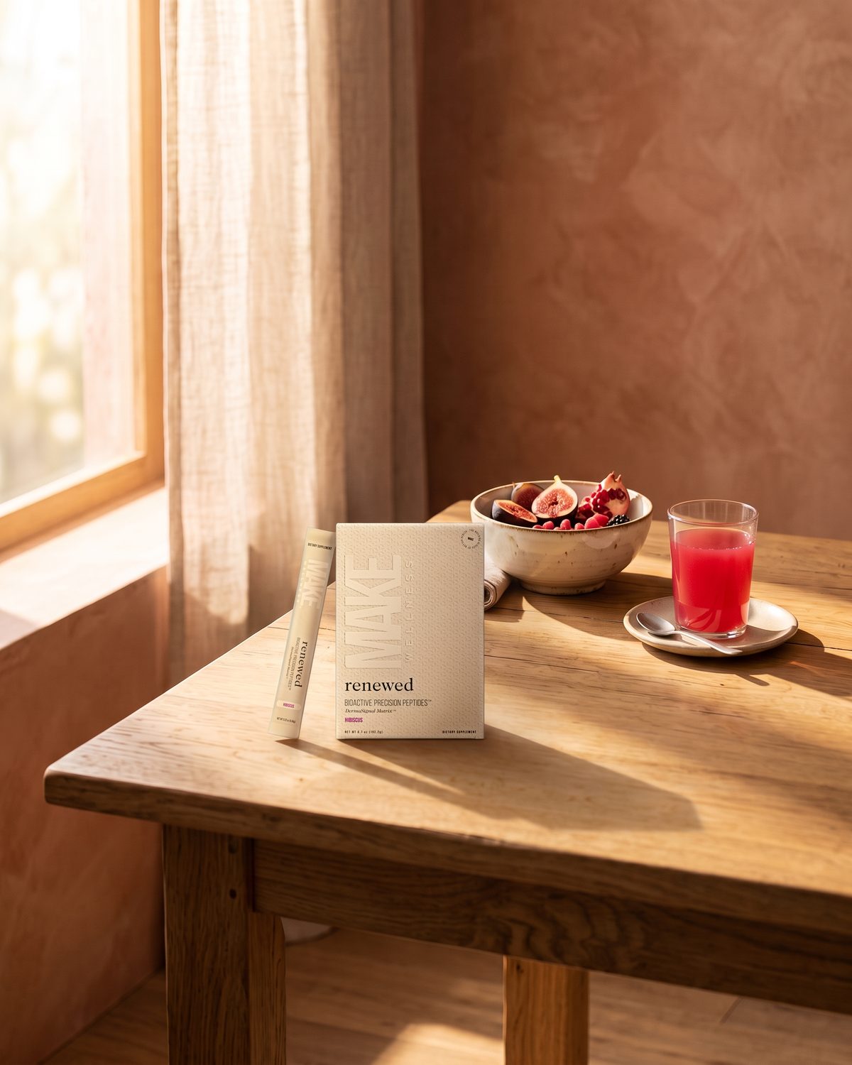 RENEWED, the MAKE Wellness hibiscus-berry peptide drink, on a breakfast table