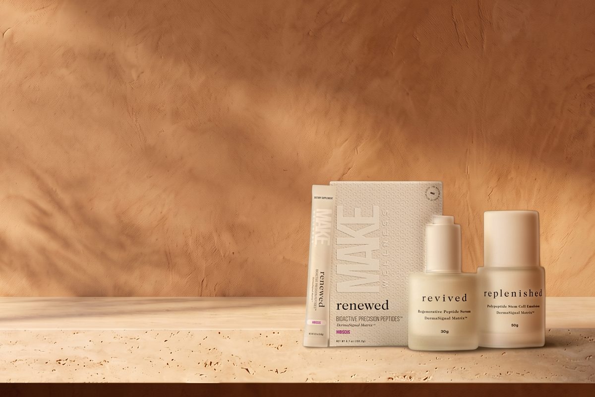 Os três produtos Precision Skincare, a caixa da bebida, o sérum e a emulsão, numa prateleira de pedra, diante de uma parede de gesso.