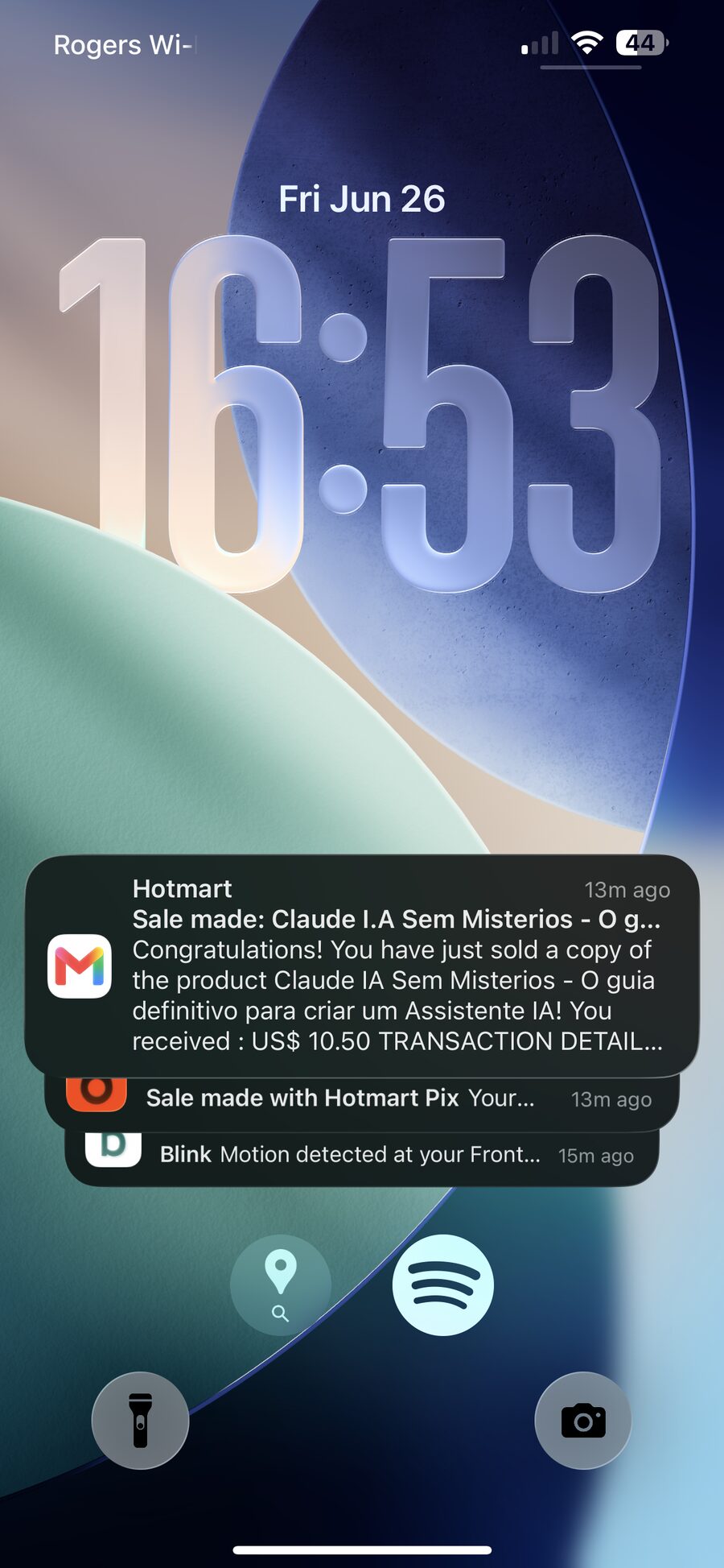 My iPhone lock screen on a Friday afternoon: a Hotmart alert that a copy of my Claude guide just sold for US$ 10.50, sitting right above a Blink notification about motion at my front door.