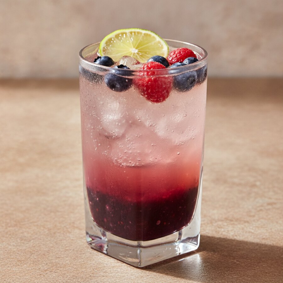 Açaí Sunrise, a vibrant purple açaí and berry sparkling drink over ice with a lime wheel