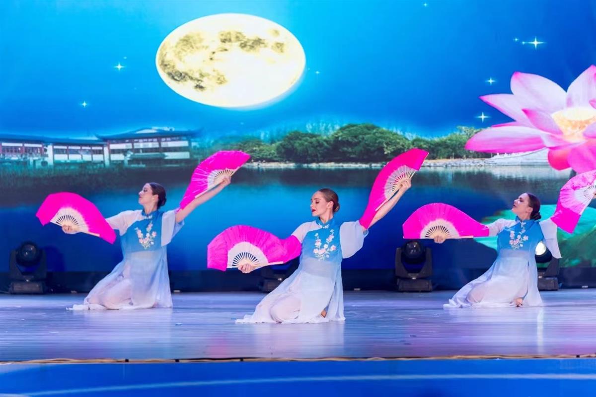 Fan dance performance with moonlit stage backdrop in Wuhan