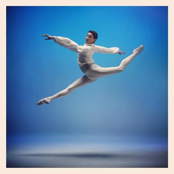 Grand jeté in studio with blue backdrop